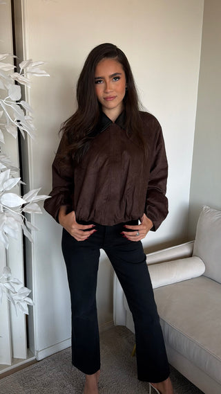 A brown jacket with a structured look, featuring a blend of polyester and elastane.